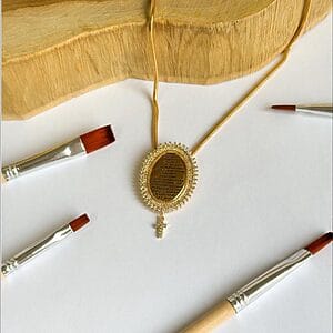 Golden Prayer Pendant Necklace featuring 18k gold-plated oval pendant with engraved prayer, pavé zirconia border, and cross charm