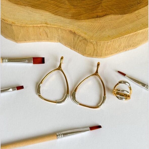 Two‑tone open teardrop earrings with silver accents and a matching sculptural ring, 18k gold plated