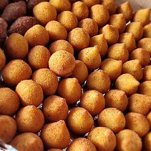 "Promotional graphic for Karamelado featuring the product '100 Traditional Brazilian Savory Snacks.' Includes a list of assorted flavors: Risole (Ham & Cheese, Ground Beef, Corn with Cheese, Four Cheese), Kibe, Cassava Ball with Ground Beef, Dulce de Leche Churros, Sausage Roll, and Chicken Coxinha. Text highlights that the combo is perfect for birthdays, celebrations, coffee breaks, and any special occasion, emphasizing Karamelado quality with fresh ingredients and full flavor."