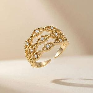 “Gold ring with interlaced bands and evenly placed sparkling crystals.”