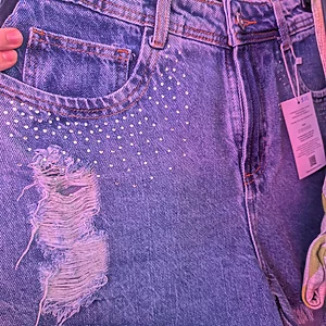 Distressed denim shorts with stud details and frayed hem by Fashion Brasil Sun and Sea.