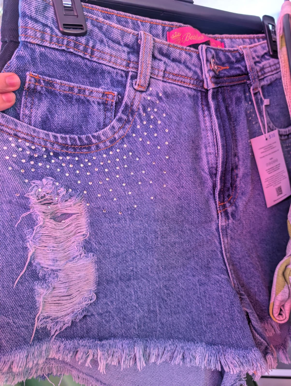 WhatsApp Image 2026 04 04 at 12.23.15 PM | Studded Distressed Denim Shorts - Fashion Brasil Sun and Sea Distressed denim shorts with stud details and frayed hem by Fashion Brasil Sun and Sea.