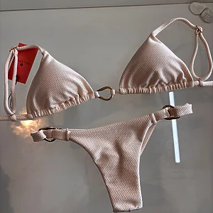 Textured sand‑tone two‑piece bikini with triangle top and side ring details, Fashion Brasil Sun and Sea.