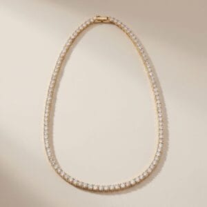Gold diamond-style necklace with brilliant round stones arranged in a continuous line, symbolizing forever love and designed as a meaningful Mother’s Day jewelry gift by Madu Joia Rara.