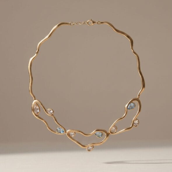 Gold diamond-style necklace with high-shine stones displayed on a soft neutral background, a luxurious Mother’s Day gift by Madu Joia Rara.