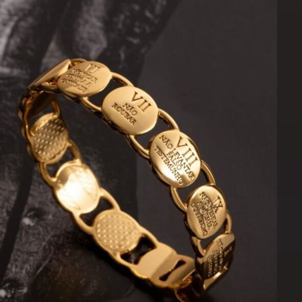 Gold engraved link bracelet with oval plates featuring Roman numerals and symbolic inscriptions, representing faith, devotion, and eternal love, designed as a meaningful Mother’s Day jewelry gift by Madu Joia Rara.