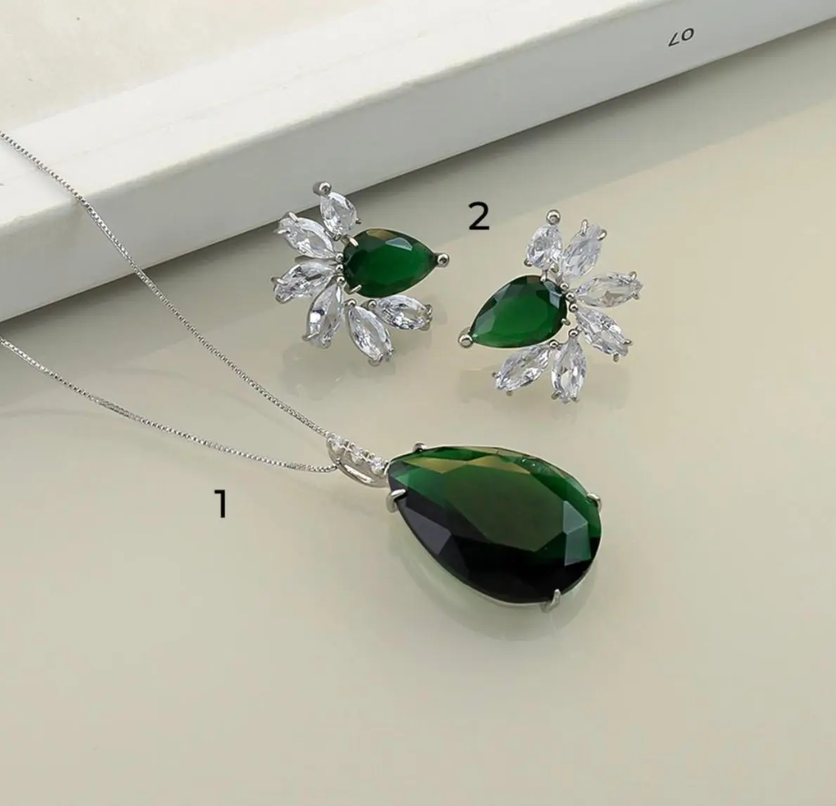 mari semijoias green crystal necklace detail | Emerald Elegance Pendant Necklace - Mari Semijoias Mari Semijoias Emerald Elegance Pendant Necklace with emerald-green teardrop crystal pendant and white rhodium chain
