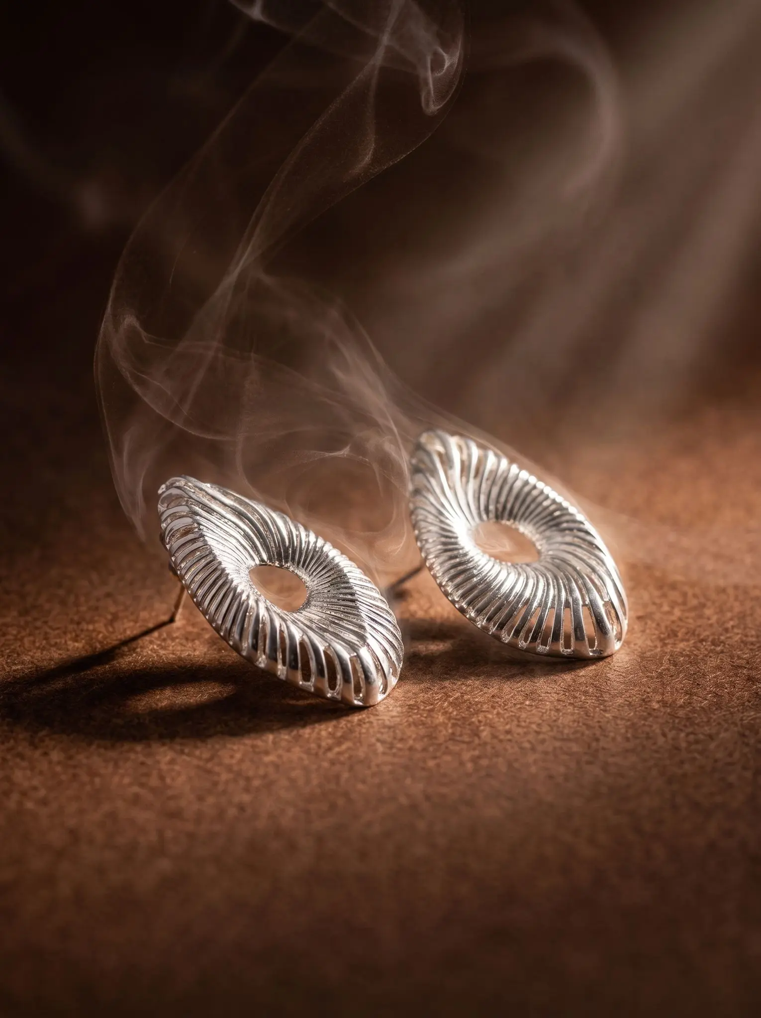 celestial wave earrings madu joia rara silver | Celestial Wave Earrings – Madu Joia Rara Silver-tone statement earrings featuring an open-center oval design with textured radiating lines inspired by ocean waves, showcasing modern elegance and artistic craftsmanship by Madu Joia Rara.