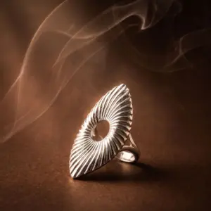Silver-tone statement ring featuring a sculptural wave-inspired design with textured radiating lines and an open center detail, showcasing modern elegance and artistic craftsmanship by Madu Joia Rara.