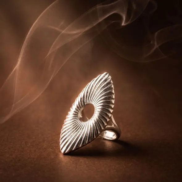 Silver-tone statement ring featuring a sculptural wave-inspired design with textured radiating lines and an open center detail, showcasing modern elegance and artistic craftsmanship by Madu Joia Rara.