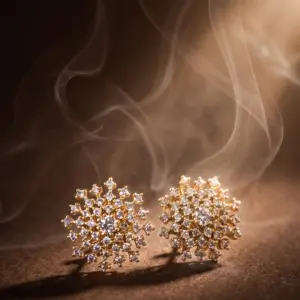 Gold-tone stud earrings featuring a radiant starburst design with sparkling zirconia stones, creating a luxurious and elegant statement by Madu Joia Rara.